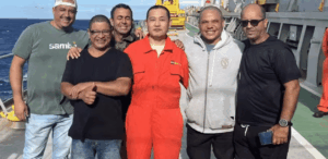 Resgate de pescadores brasileiros por tripulação chinesa após naufrágio no mar, em momento de confraternização no navio.