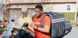 Motoboy com mochila de entrega manuseando pacotes sobre a moto, representando uma nova lei de segurança reforçada com rastreamento em SP.