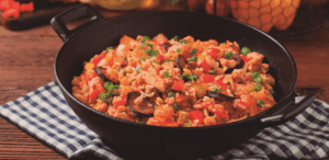 Prato típico de Nova Orleans, destaque entre as melhores cidades para comer em 2025, servido em panela de ferro com arroz, legumes e carnes.