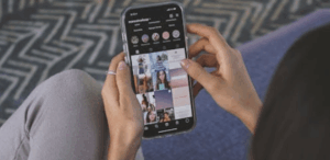 Pessoa rolando o feed do Instagram no celular, sentada em ambiente interno