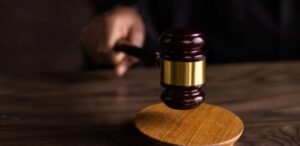 Martelo de juiz sendo utilizado em tribunal, simbolizando decisões judiciais e aplicação da lei