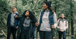 Turismo sustentável com grupo de pessoas caminhando em trilha ecológica cercada por natureza preservada