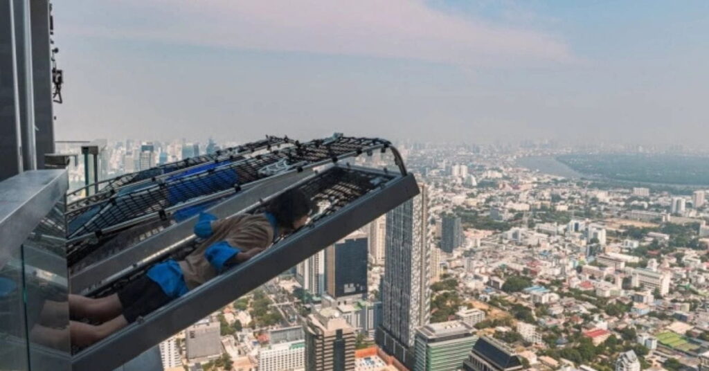 Pessoa aproveita o mirante em Bangkok inclinado a 296 metros de altura com vista panorâmica da cidade
