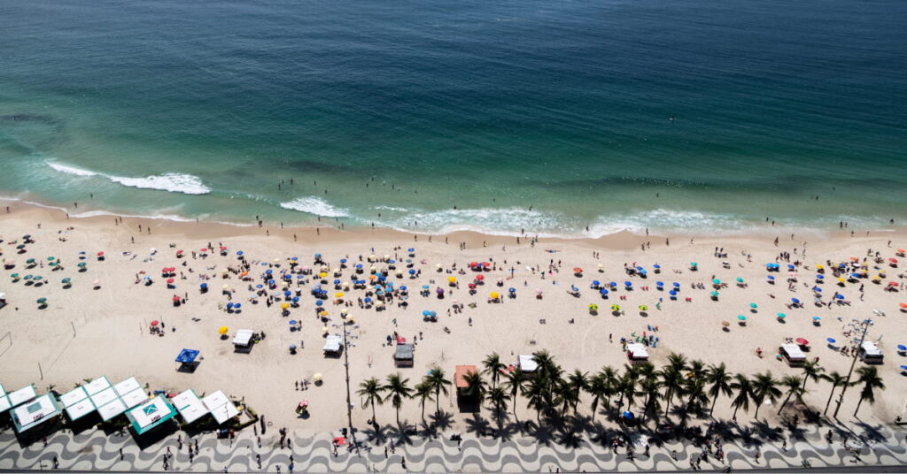 Vista aérea mostra banhistas aproveitando praias limpas no Rio em dia ensolarado e com mar calmo