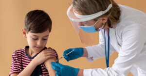 Menino recebendo vacina no braço durante a vacinação contra a gripe