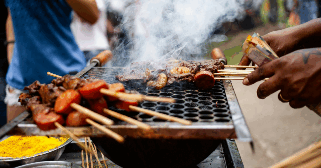 Pessoas assando carne na brasa em uma churrasqueira