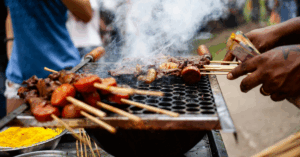 Pessoas assando carne na brasa em uma churrasqueira