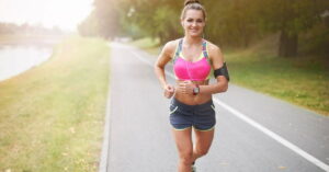 Mulher correndo ao ar livre com expressão de bem-estar, simbolizando a euforia na corrida e seus efeitos positivos no corpo