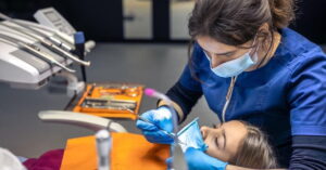 Dentista atende jovem durante ação de tratamento dental gratuito no Brasil