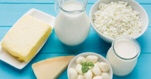 Garrafa de leite de búfala ao lado de queijos, iogurte e ricota produzidos a partir do leite