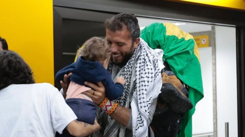 Missionário brasileiro em Gaza abraça o filho ao retornar ao Brasil após missão humanitária.
