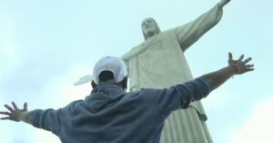 Pessoa em situação de rua visita o Cristo Redentor de braços abertos