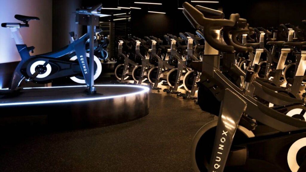 Academia de luxo Equinox na Califórnia com sala de spinning moderna e iluminação minimalista.
