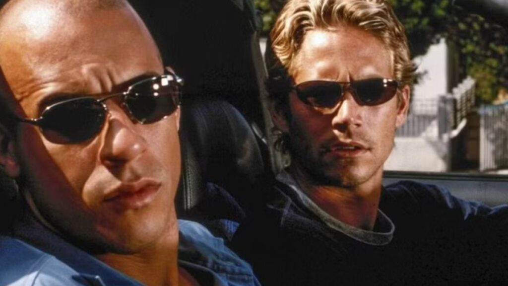 Vin Diesel e Paul Walker lado a lado em uma cena clássica da franquia Velozes e Furiosos, representando a forte conexão entre Dom Toretto e Brian O’Conner, que será homenageada no último Velozes e Furiosos.