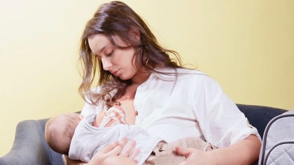 Mãe amamentando bebê em cadeira de amamentação no Dia Mundial da Amamentação