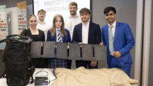 Rebecca Young apresenta com engenheiros o protótipo do cobertor solar para moradores de rua.