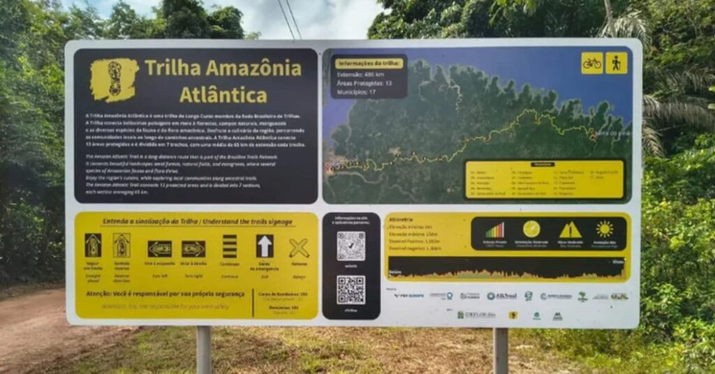 Placa informativa da Trilha Amazônia Atlântica, no Pará, com mapa do percurso e orientações para ciclistas e caminhantes.