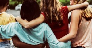 Grupo de amigas caminhando juntas, representando amizades duradouras e bem-estar.