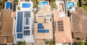 Telhados de casas com painéis solares em bairro residencial, representando o avanço da energia solar em cidades brasileiras.