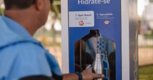 Estação de água na COP30 sendo utilizada para abastecer garrafa reutilizável em Belém.