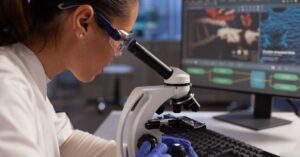 pesquisadora observa amostra em laboratório moderno durante projeto ligado à parceria Einstein–Stanford