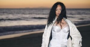 Conceito visual relacionado às Empresas bilionárias de Rihanna, mostrando figura feminina em cenário litorâneo ao entardecer.