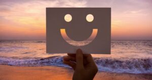 “Passos para a felicidade representados por sorriso ao pôr do sol, simbolizando bem-estar e equilíbrio emocional.”