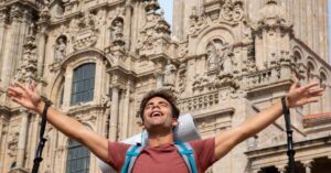 regularização de imigrantes na Espanha representada por imigrante celebrando em frente a catedral histórica