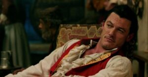 vilões da disney em cena de live-action com personagem masculino em traje de época, postura confiante e expressão arrogante