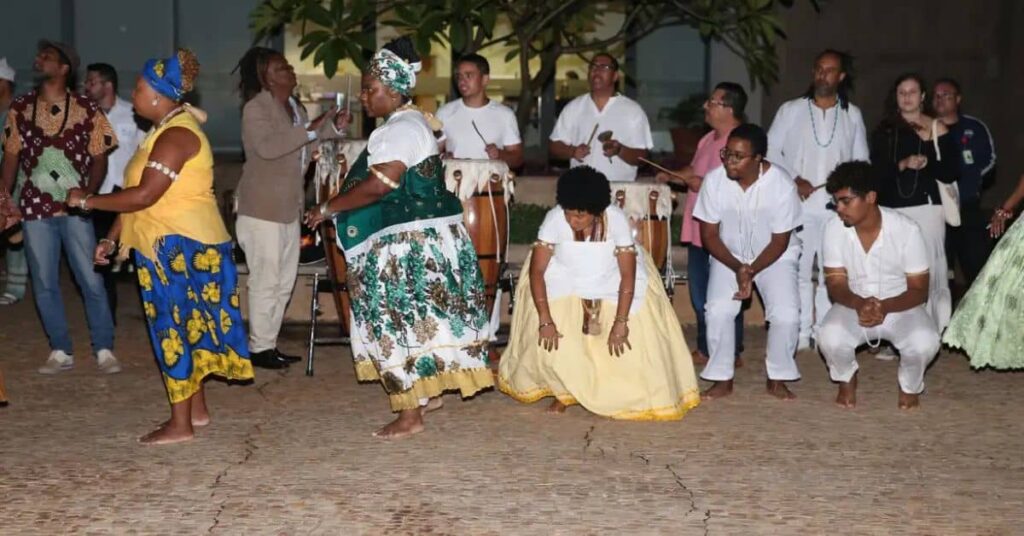 Ritual de matriz africana com homens e mulheres vestindo trajes tradicionais durante celebração ligada ao combate à intolerância religiosa.