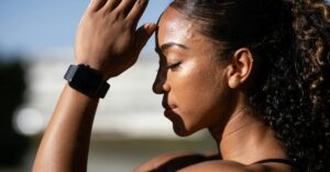 Mulher em momento de pausa e concentração ao ar livre, representando o silêncio na vida moderna