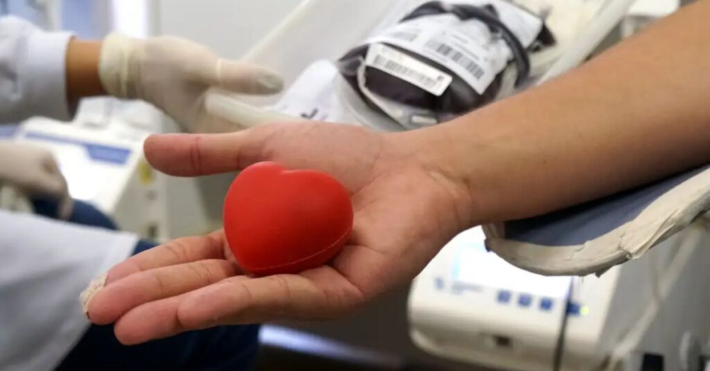 doação de sangue no Carnaval com doador segurando coração simbólico em hemocentro