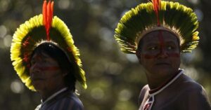 Lideranças indígenas com cocares tradicionais representando a memória indígena e a preservação cultural